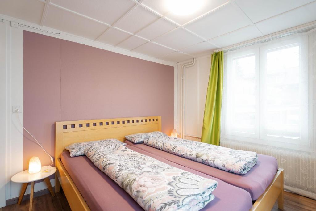 1 dormitorio con 2 camas y ventana en Apartment Heimathus, en Amden