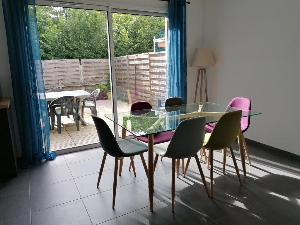 une salle à manger avec une table et des chaises en verre dans l'établissement Maison climatisée 3 chambres au coeur des vignobles bordeaux Léognan, à Léognan