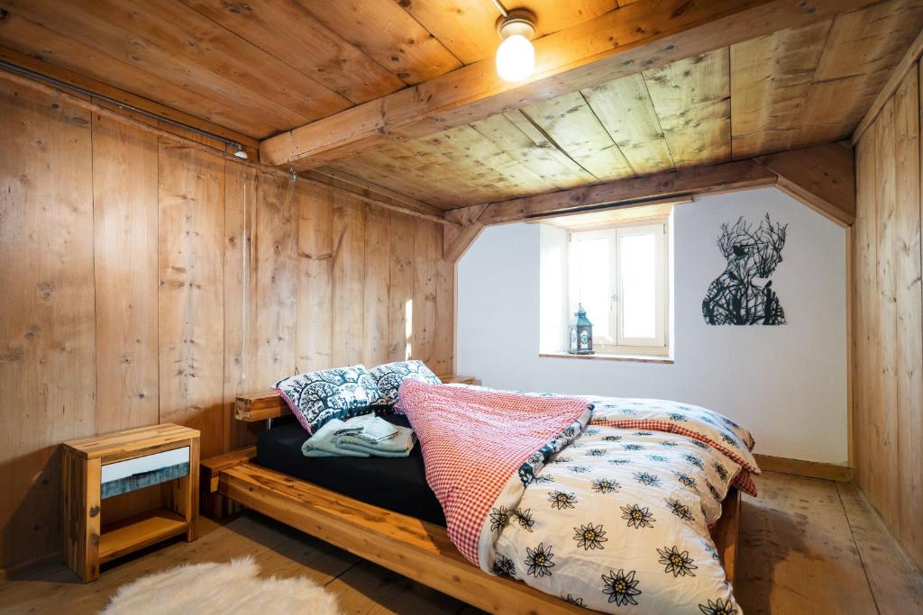 a room with a couch in a room with wooden walls at Cottage Obereichholzberg in Weesen