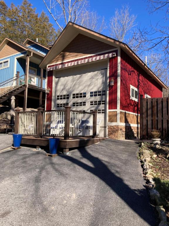uma casa com uma garagem vermelha e branca em All Seasons Treehouse Village em Eureka Springs
