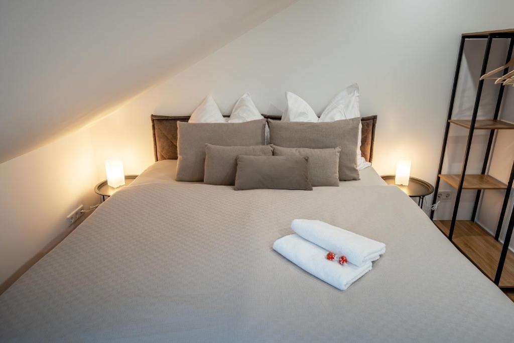 a bed with two towels and two candles on it at Apartment Milse - Modern. Stylisch in Bielefeld