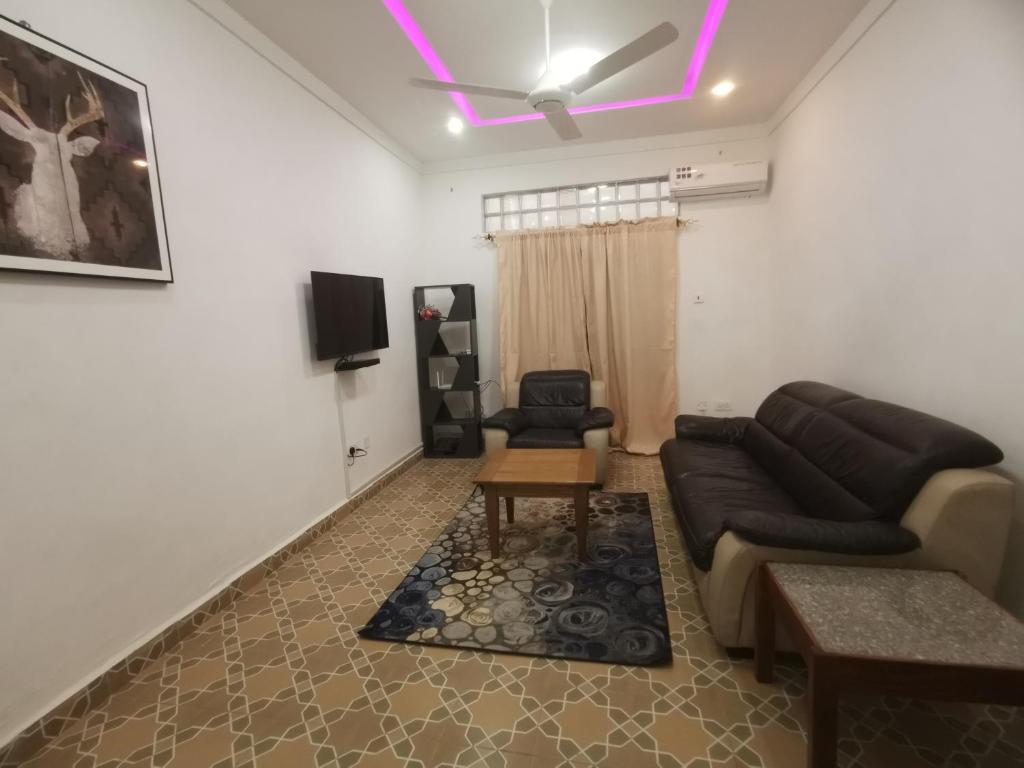 een woonkamer met een bank en een tv bij BARAKAH ESTATE APARTMENTS in Sere Kunda