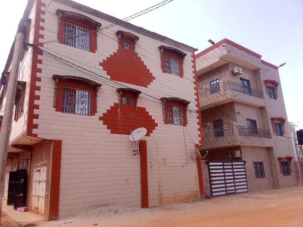 a white building with red brick at BARAKAH ESTATE APARTMENTS in Sere Kunda