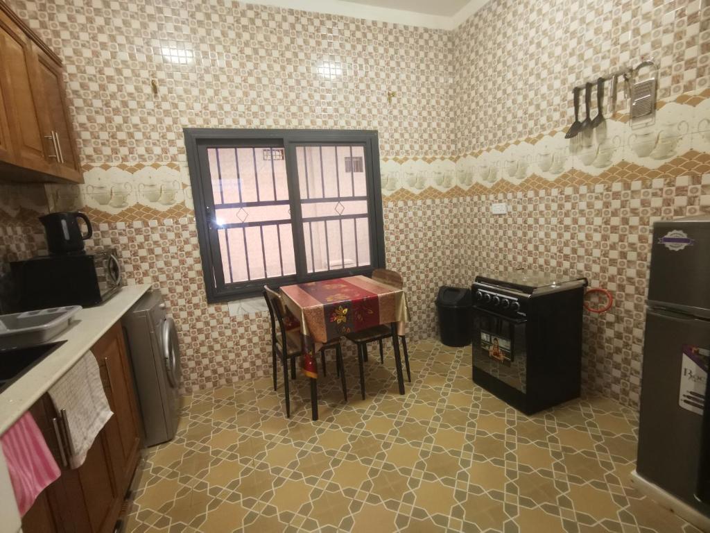a kitchen with a table and a window in it at BARAKAH ESTATE APARTMENTS in Sere Kunda