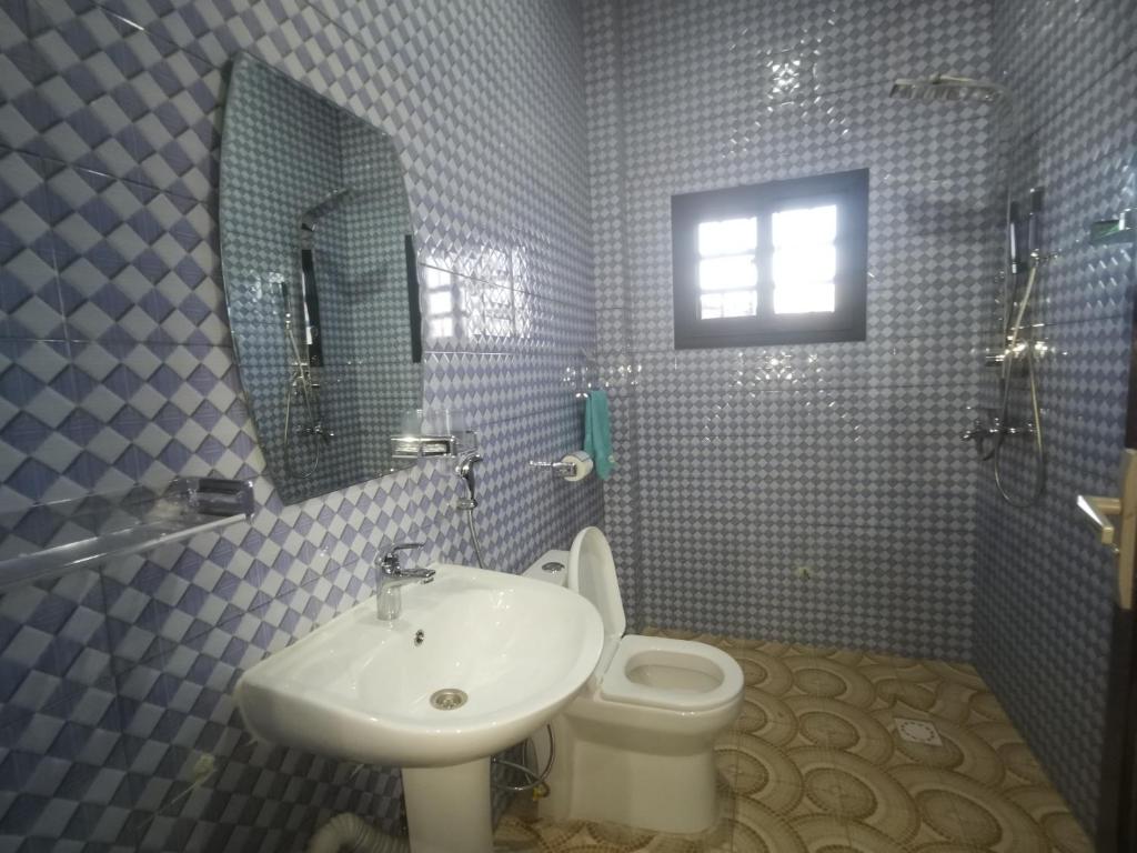 a bathroom with a sink and a toilet and a mirror at BARAKAH ESTATE APARTMENTS in Sere Kunda