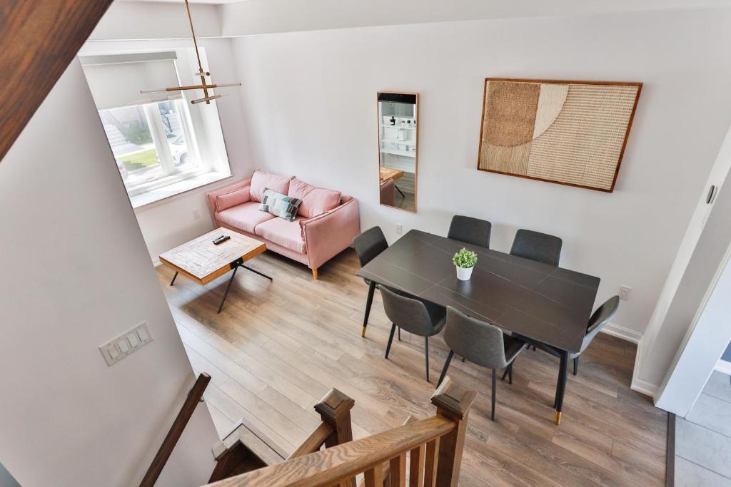 ein Wohnzimmer mit einem Tisch und einer rosa Couch in der Unterkunft 3bdr townhouse in Downsview Park - Free parking - 25 min to Downtown in Toronto