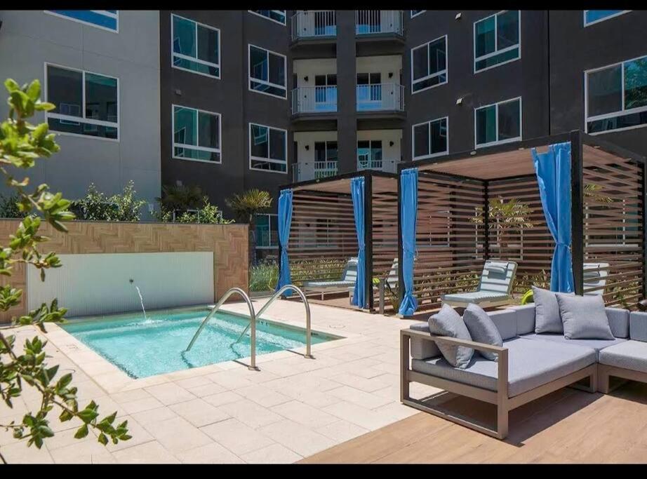 eine Terrasse mit einem Sofa und einem Pool vor einem Gebäude in der Unterkunft Huge 2bd Apt Near Disneyland & Anaheim Conv Centr in Orange