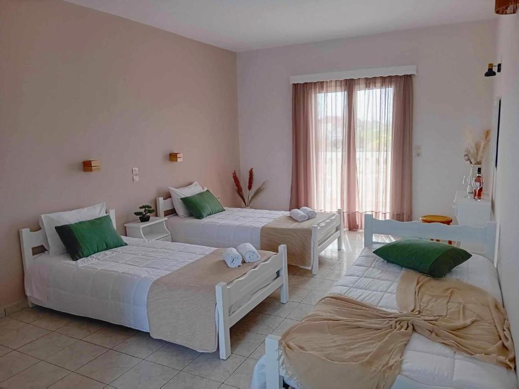 two beds in a room with green and white at Lunzi Verde in Laganas