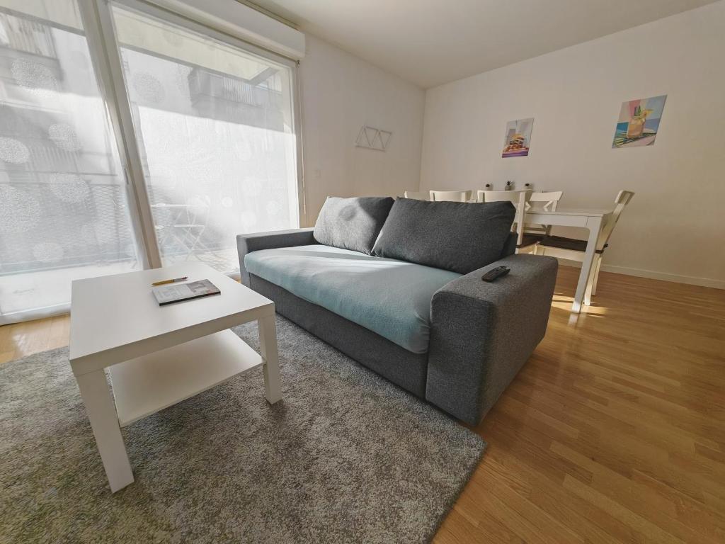 ein Wohnzimmer mit einem Sofa und einem Tisch in der Unterkunft Paris 15 min Appartement tout confort 6 couchages in Vitry-sur-Seine
