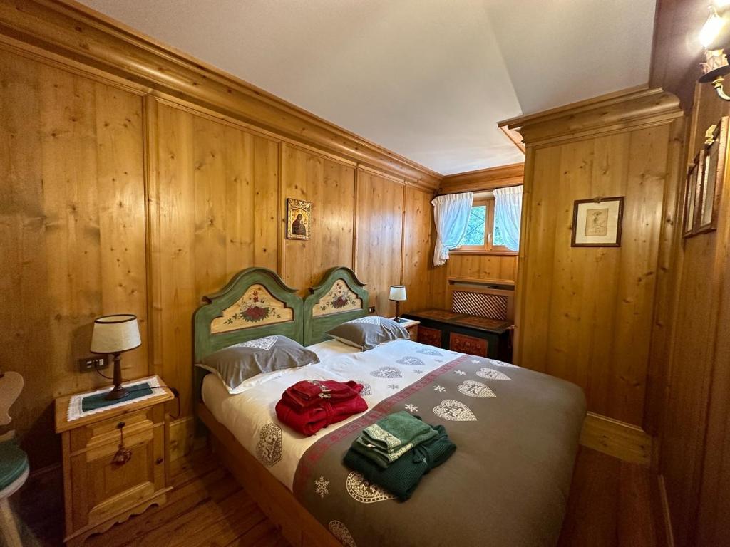 a bedroom with a bed with two bags on it at Pecol Cozy Apartment R&R in Cortina dʼAmpezzo