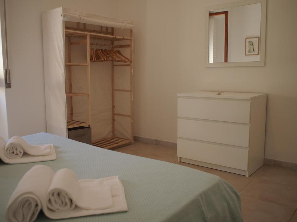 1 dormitorio con 1 cama con 2 toallas en Asfodelo 97, en Alghero