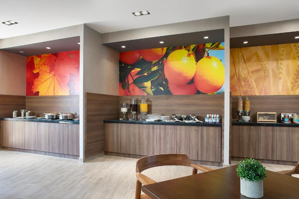 uma sala de jantar com uma mesa e pinturas na parede em Fairfield Inn & Suites by Marriott Aguascalientes em Aguascalientes