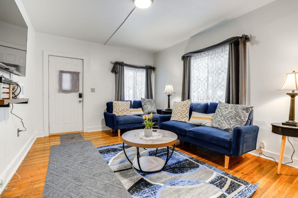 una sala de estar con sofás azules y una mesa. en Niles Vacation Rental Near St Joseph River!, en Niles
