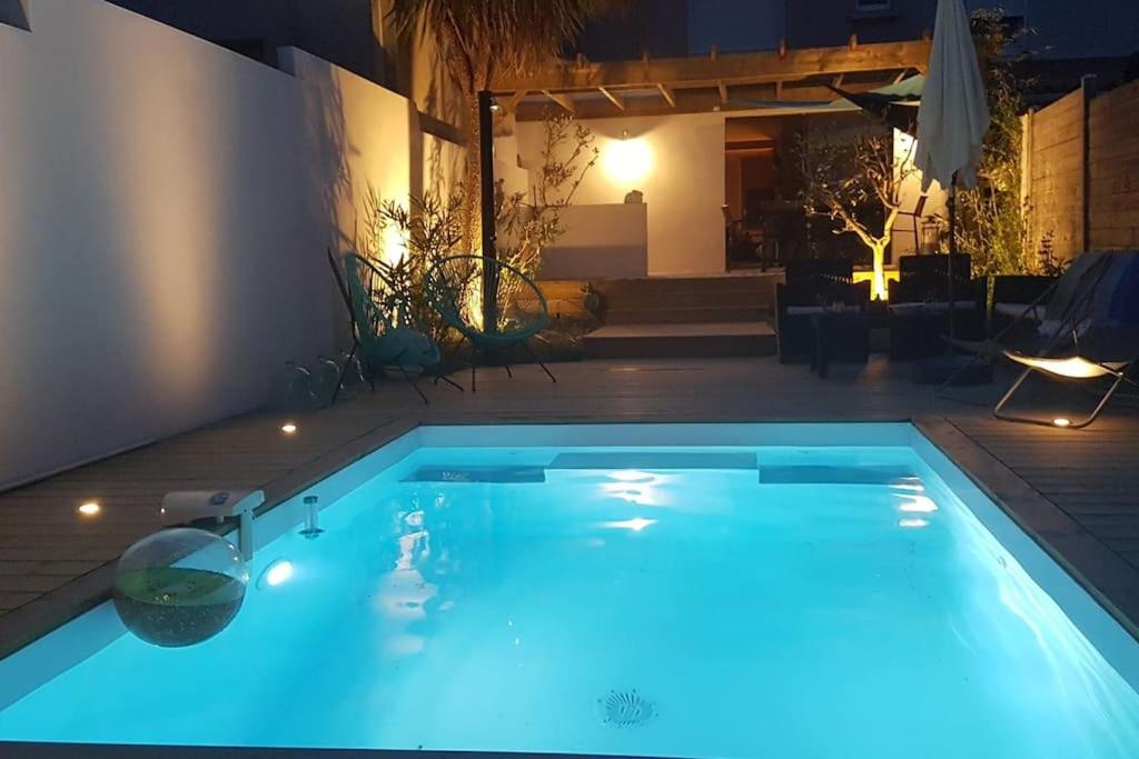 une piscine éclairée la nuit dans l'établissement Villa Baliste et sa piscine aux Sables d'Olonne, à Château-dʼOlonne
