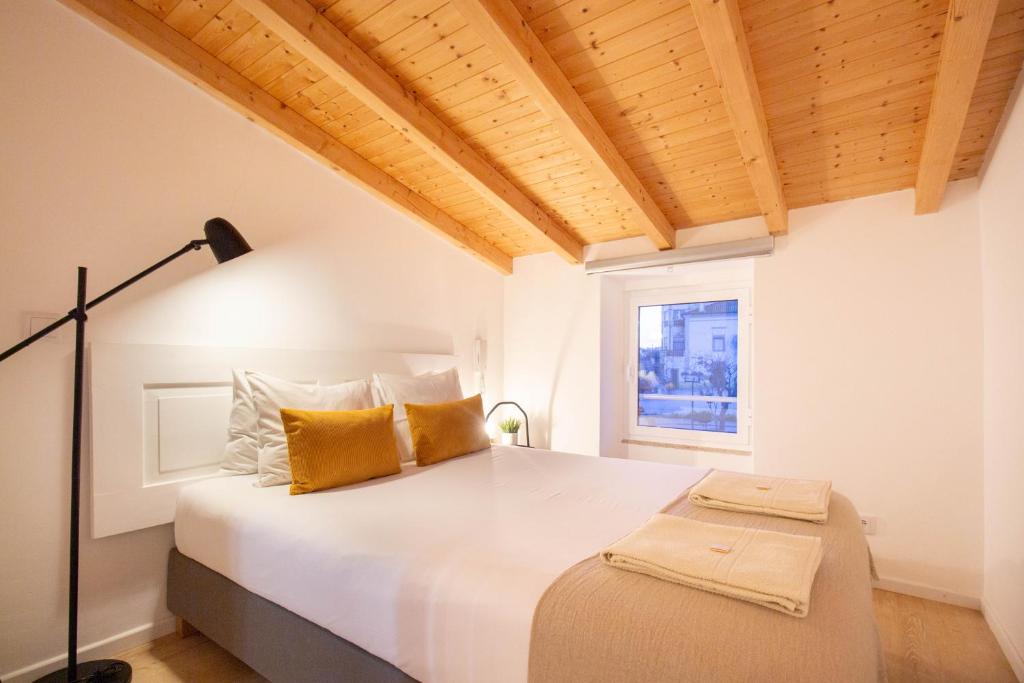 um quarto com uma grande cama branca e uma janela em Casinha da Póvoa -Turismo Aldeia em Castelo de Vide