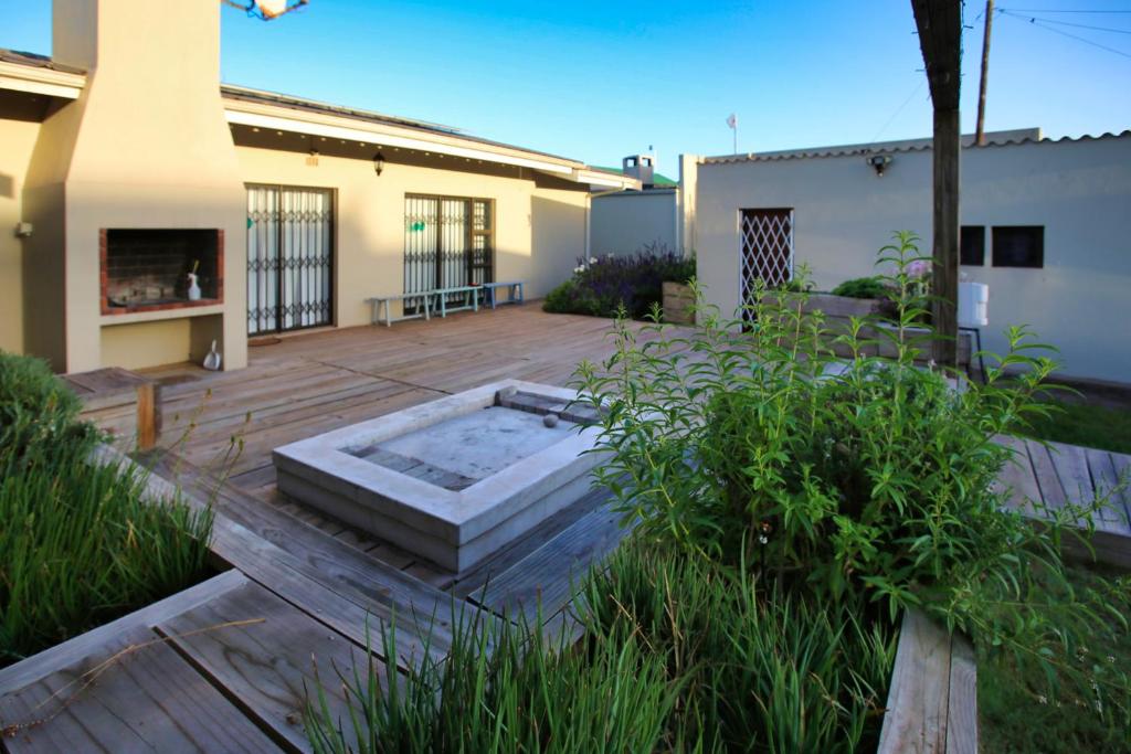 a backyard with a hot tub on a wooden deck at Sandy Feet Langebaan in Langebaan