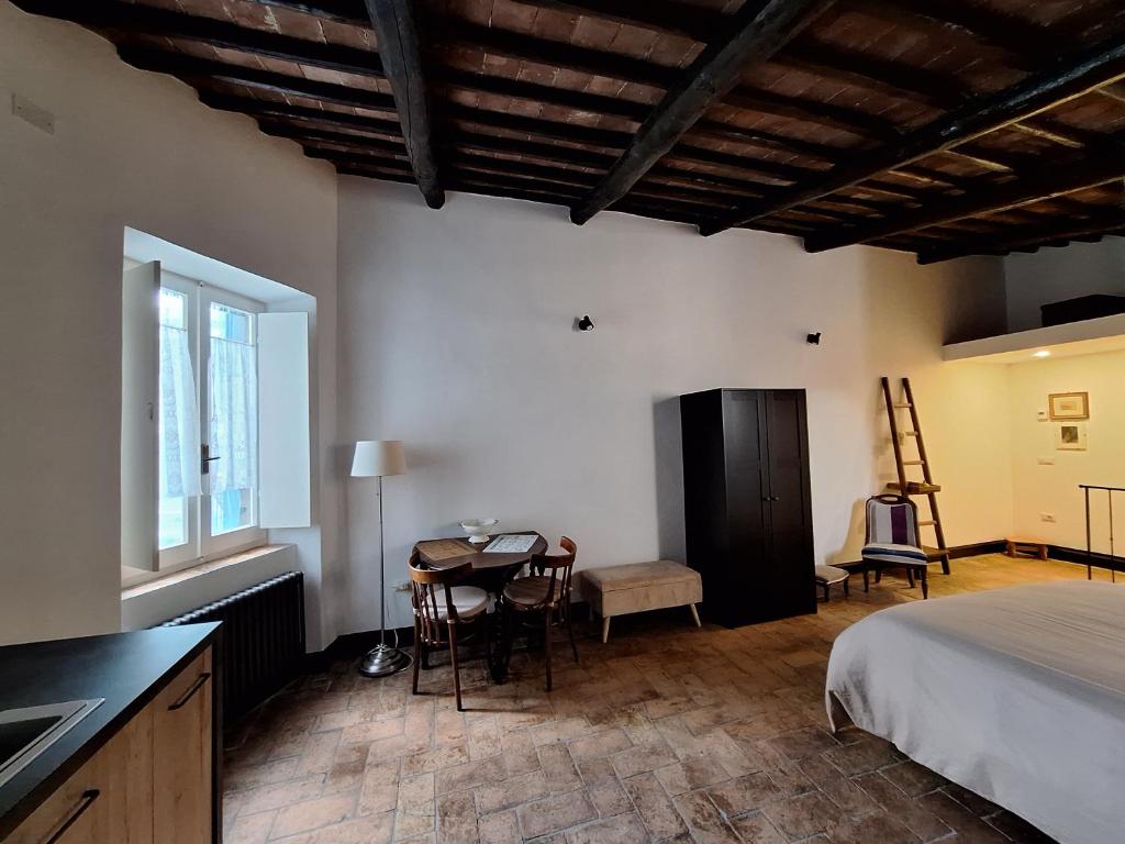 Cet appartement comprend une chambre avec un lit et une table ainsi qu'une cuisine. dans l'établissement Casetta al Parione, à Bolsena