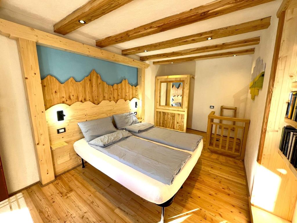 1 dormitorio con 1 cama en una habitación con suelo de madera en Nostalgie di un tempo nelle Dolomiti, en Pergine Valsugana