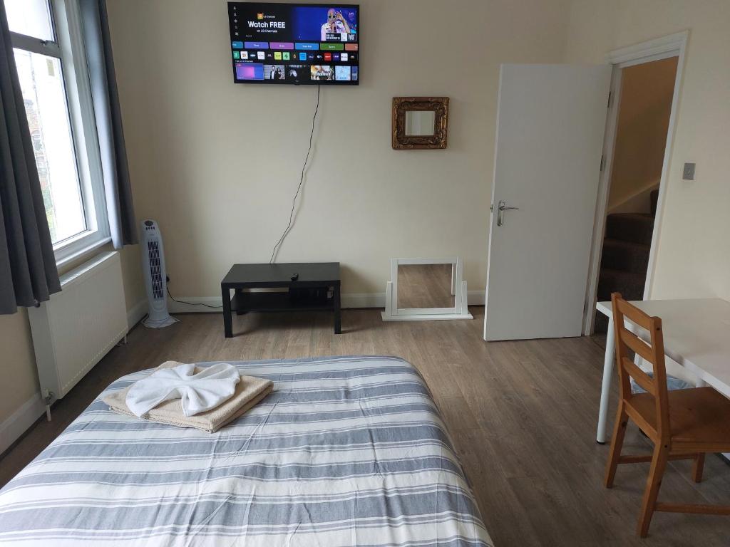 1 dormitorio con 1 cama y TV en la pared en Family friendly 3 Bedroom Flat Zone 2 - children stay free! en Londres