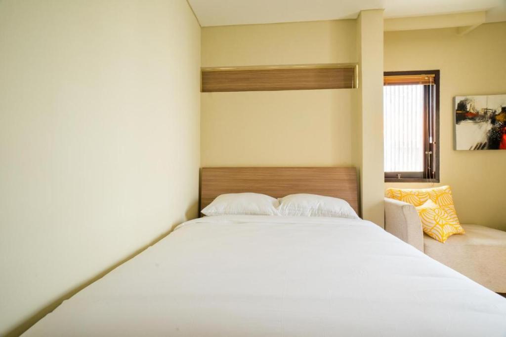 a bedroom with a large white bed and a window at Comfortable Villa in Quiet Area in Nusa Dua