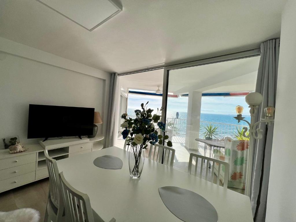 a living room with a table with a vase of flowers at Bello Horizonte Apartman 4B in Salou