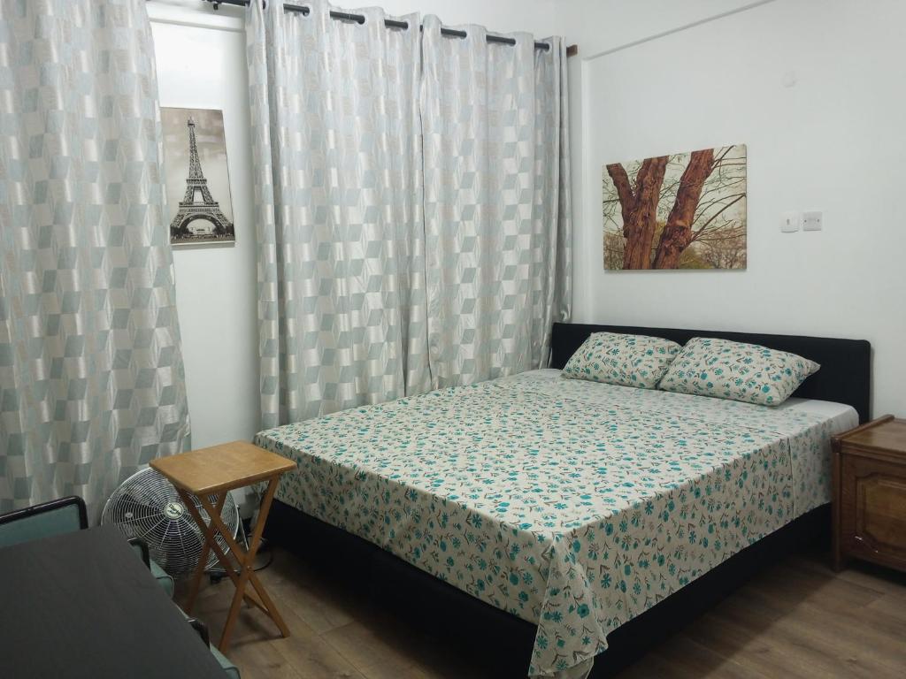 um quarto com uma cama e uma janela com cortinas em Haven Apartment em Mombasa