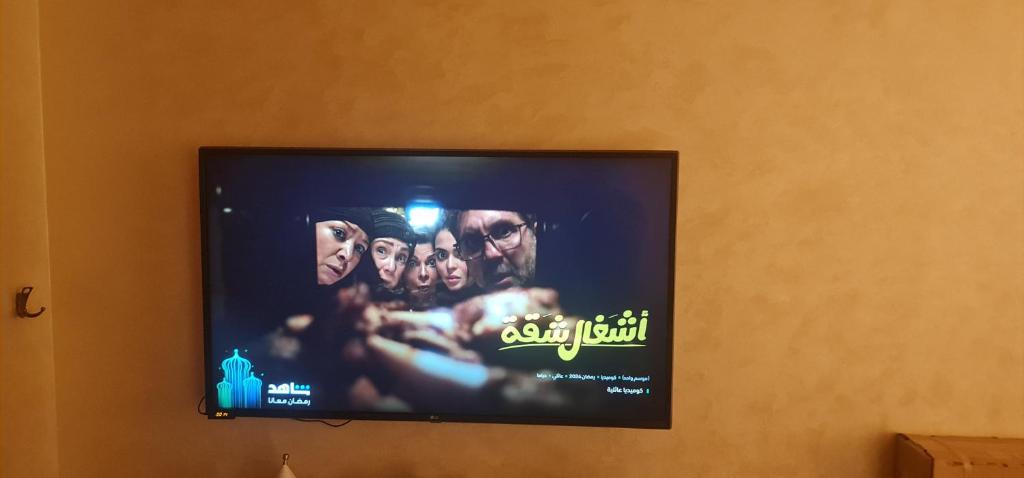 TV de pantalla plana colgada en la pared en شقه بكورنيش النيل en Al Ma‘şarah