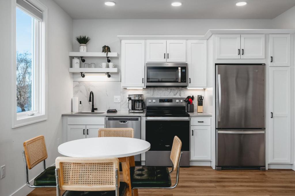a kitchen with white cabinets and a table with chairs at Downtown Traverse City Apartment near West Bay in Traverse City