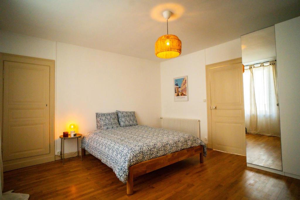 1 dormitorio con 1 cama y 1 lámpara en La Jeannette - séjour premium tout inclus dans une maison proche gare-centre avec lit 160 Emma, terrasse, parking et plus, en Châteauroux