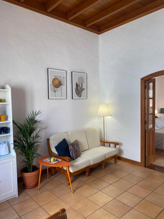 een woonkamer met een bank en een tafel bij Casa Origenes in Haría