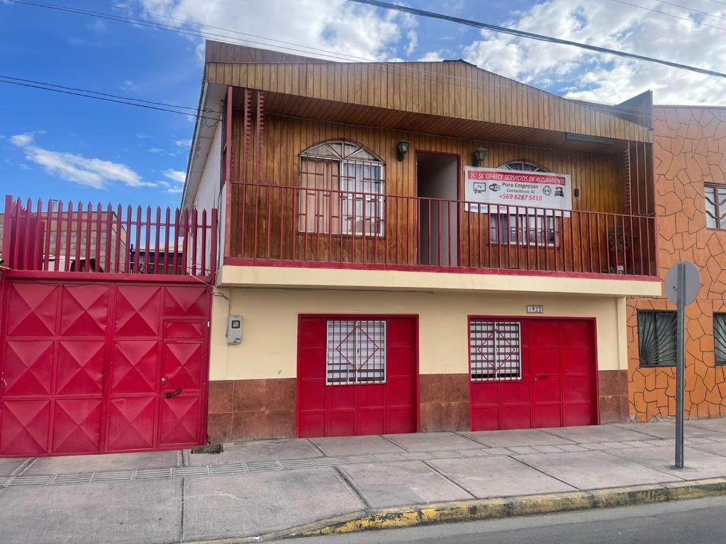 un edificio con puertas rojas de garaje en una calle en Hostal Las Ñipas en Calama