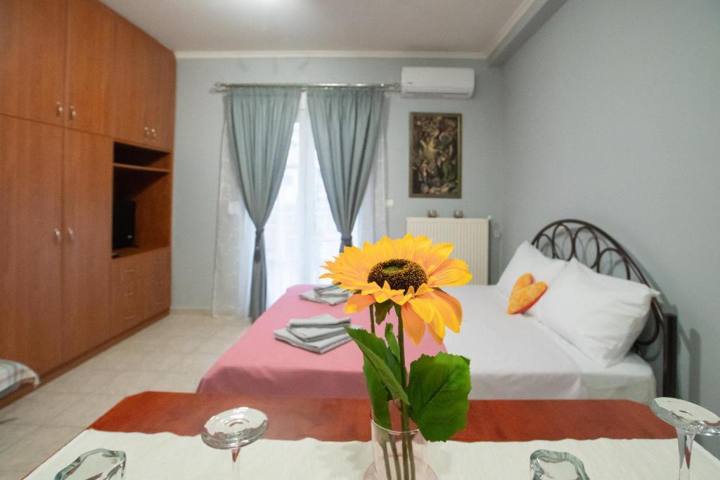 a bedroom with a bed with a flower on a table at RIRIKA APARTMENT in Igoumenitsa
