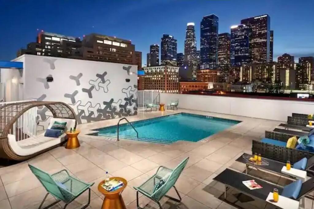 a rooftop pool on a building with a city skyline at Cozy 3bed Condo with balcony & a rooftop pool in Los Angeles