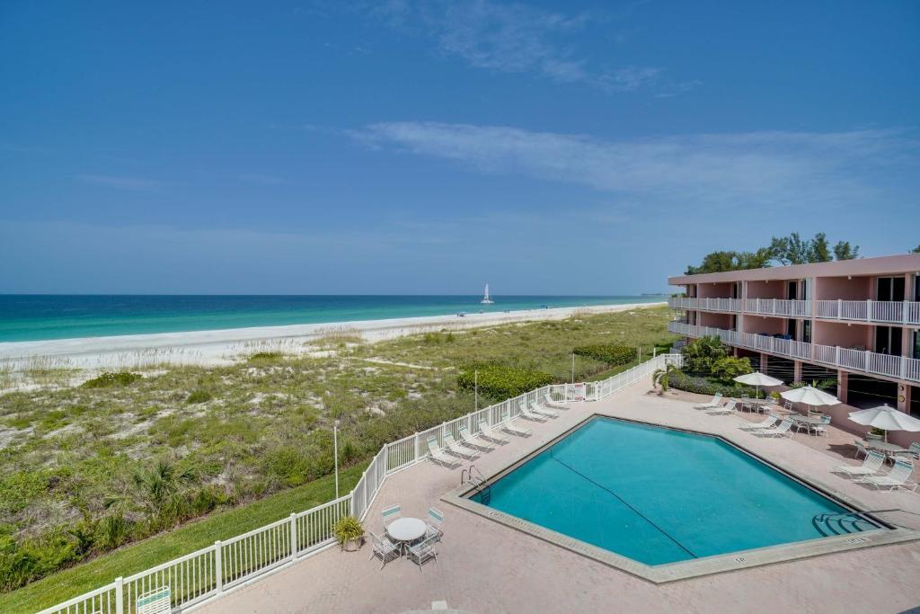 an aerial view of a hotel with a swimming pool and the beach at Spectacular Sunsets at this Beachfront Condo in Bradenton Beach