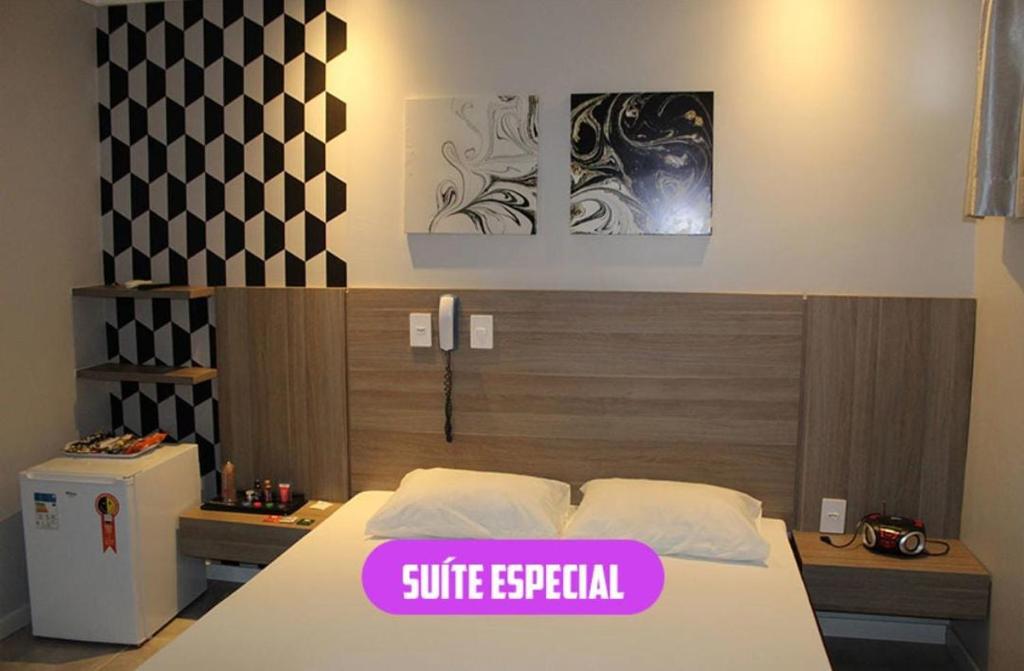 帕圖布蘭科的住宿－Motel Status (only adults)，一间卧室,床上有紫色标牌