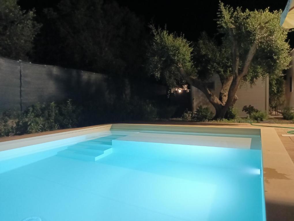 una piscina iluminada por la noche en Leporano villa MADIA con piscina, Taranto, en Leporano Marina