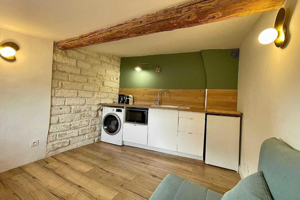 cocina con lavadora y secadora en una habitación en Atypical apartment - near garden, en Montpellier