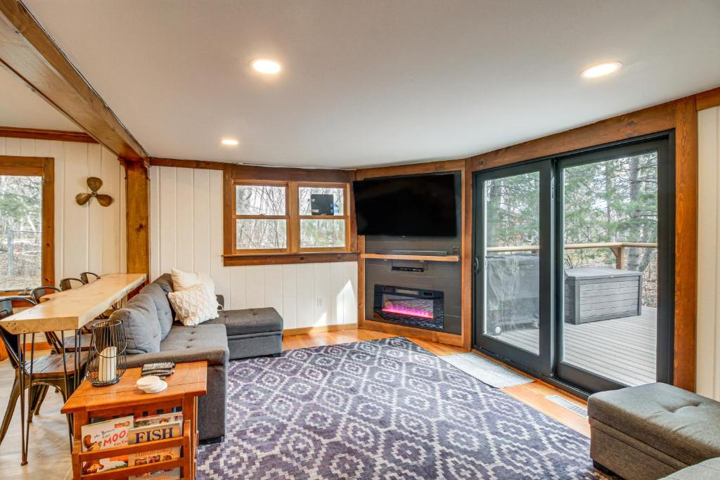 uma sala de estar com um sofá e uma televisão em Waterfront Duluth Cabin with Deck and River View! em Duluth