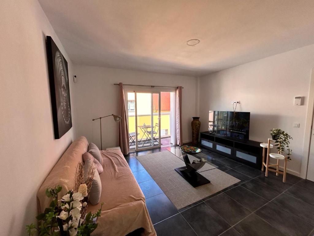a living room with a couch and a flat screen tv at Casa Daja: uw thuis in Tenerife in Las Lagunas
