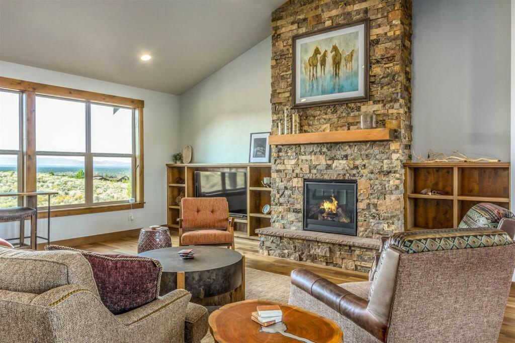- un salon doté d'une cheminée en pierre et de meubles dans l'établissement Luxurious Home Beautiful Views Family Friendly, à Powell Butte