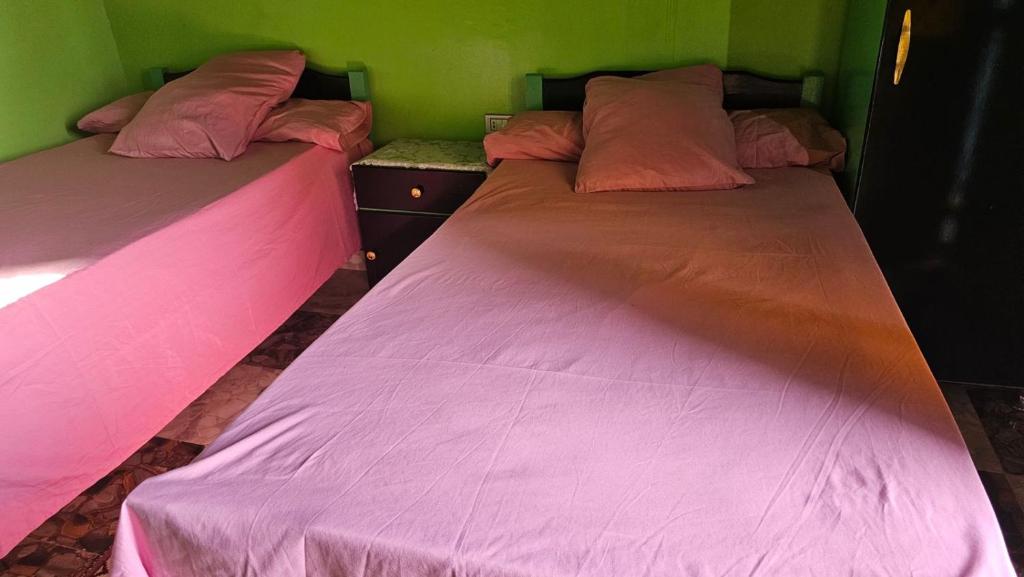 dos camas sentadas una al lado de la otra en una habitación en Taam Al beeyout en Naj‘ al Maḩaţţah