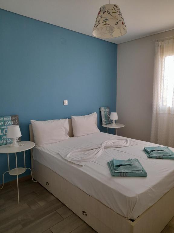 a bedroom with a large bed with a blue wall at Little Octopus in Kalamaki Heraklion
