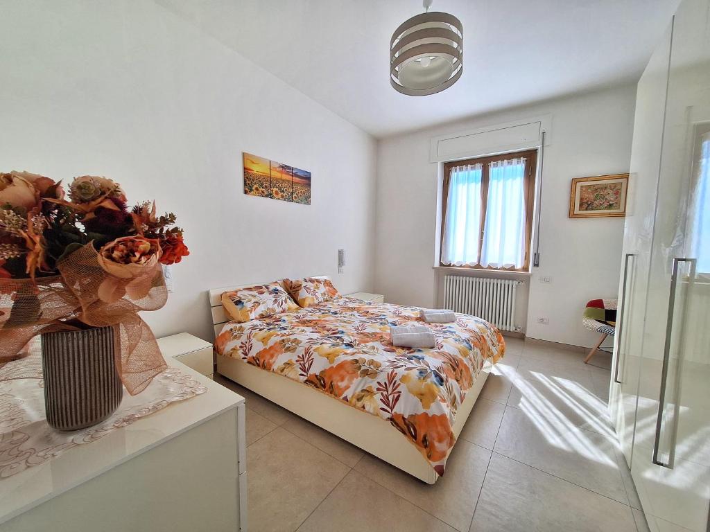 a bedroom with a bed and a vase of flowers at La casa di Lilly in Volargne