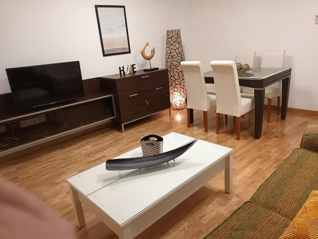 uma sala de estar com uma televisão e uma mesa com uma prancha de surf em Apartamento Fonseca by Cloe em Salamanca