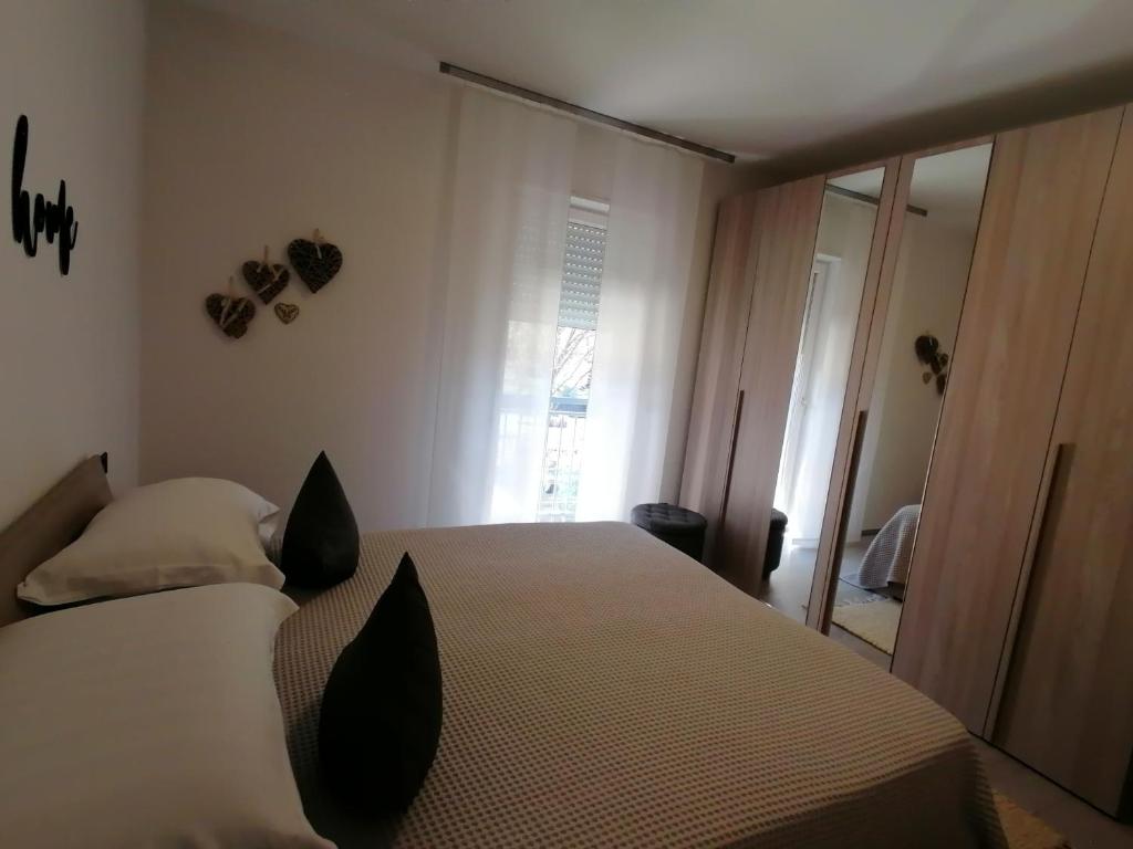 een slaapkamer met een bed met zwarte kussens en een raam bij Appartamento Meridiana in Arco
