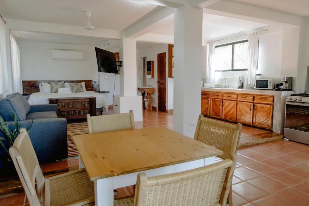 a kitchen and living room with a table and a bed at Ocean view studio in Pelada! in Nosara