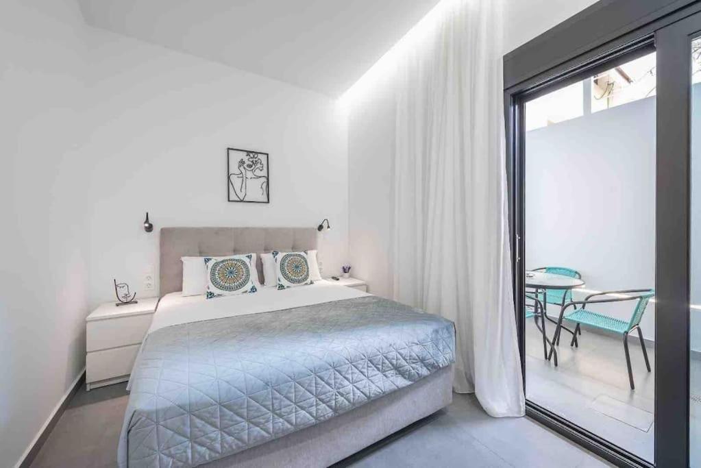 een slaapkamer met een bed, een tafel en een raam bij Cozy apartment in a new building apartment 4 in Piraeus