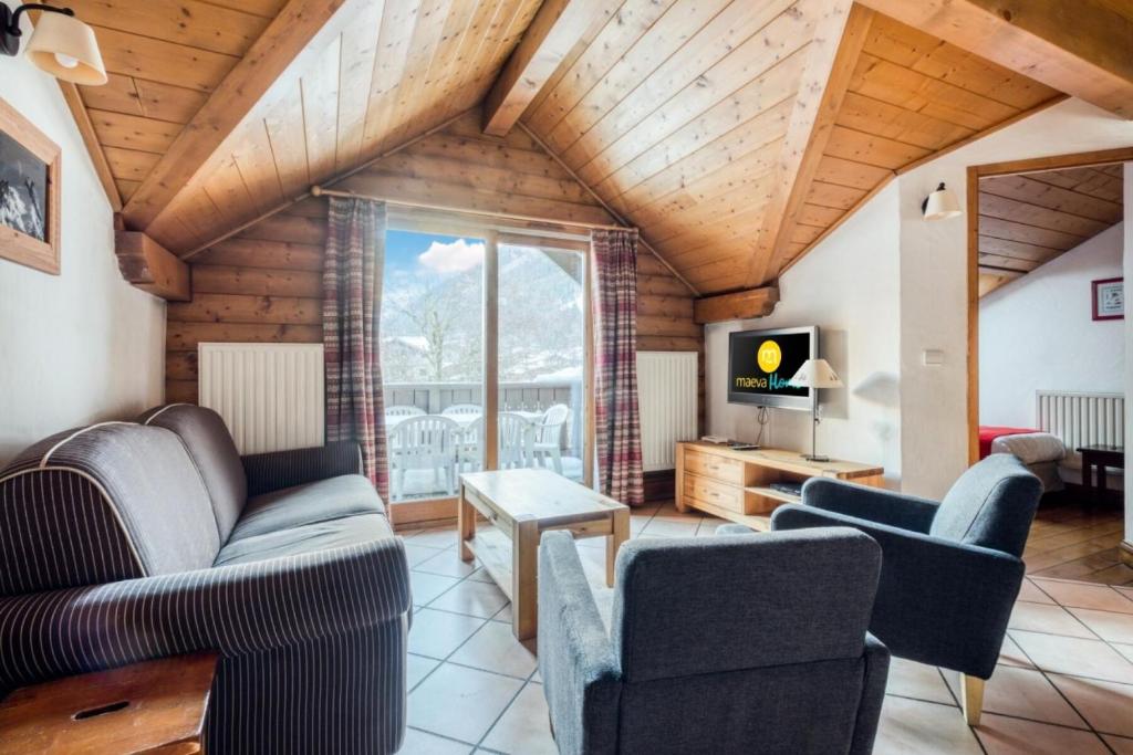uma sala de estar com sofás e uma televisão em Résidence La Ginabelle - maeva Home - Appartement 4 Pièces 8 Personnes - Séle 65 em Chamonix-Mont-Blanc