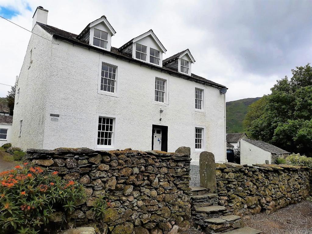 a large white house with a stone wall at 1 Bed in Keswick 86395 in Rosthwaite