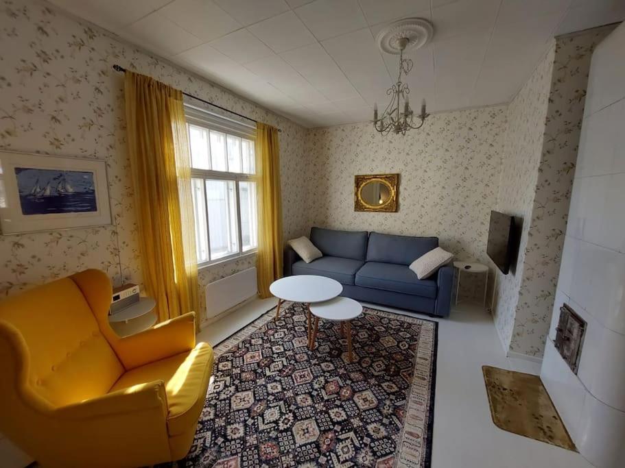 sala de estar con sofá azul y mesa en Charming wooden house apartment 48 m2, en Turku